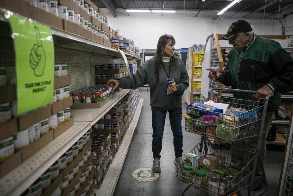 A volunteer at HEART picks up a can for David's cart