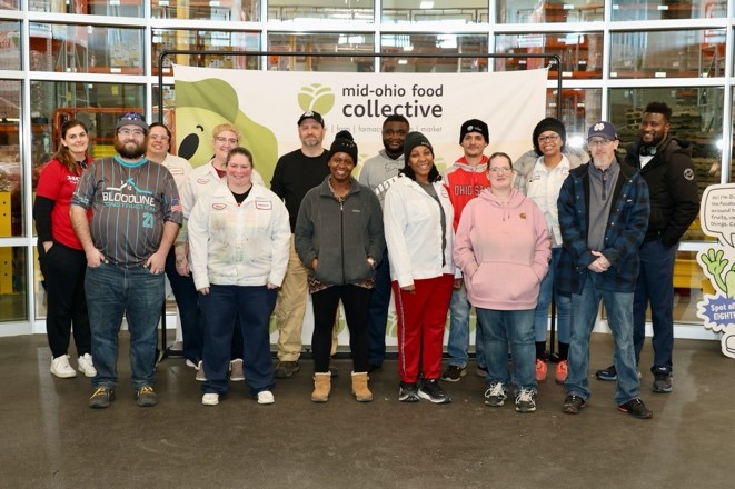 Honda volunteers pose for a group photo in front of an MOFC banner