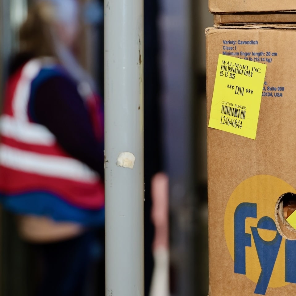 Box of produce with Walmart employee in the background