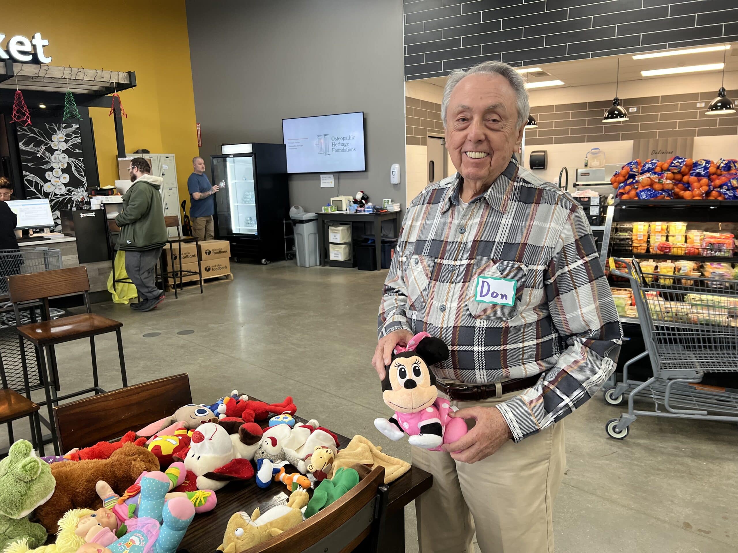volunteer holds up stuffed animals