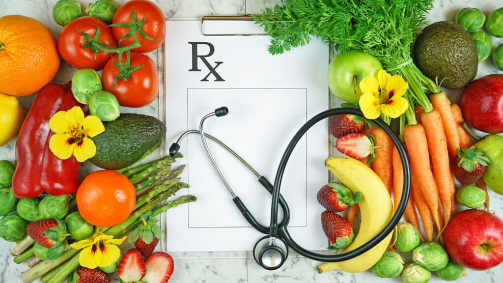 Fruit and vegetables surround an Rx letter and stethoscope
