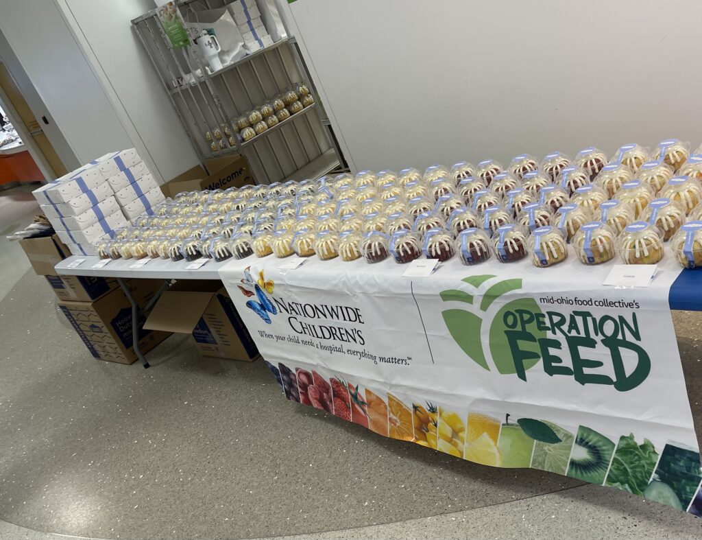 A table full of baked goods with a banner of Nationwide Children's Hospital and Operation Feed